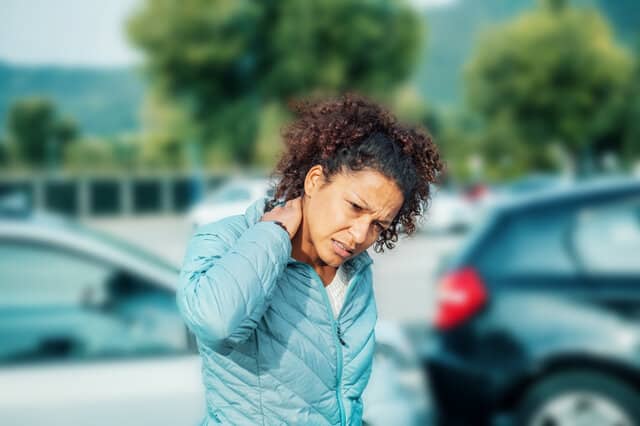 Woman feeling neck ache after bad cars pile up