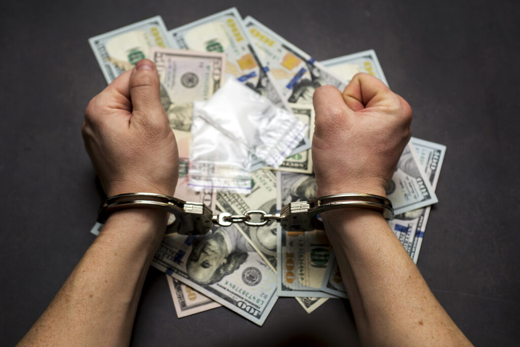 Man In Handcuffs With Money And Drugs On Dark Background The Co