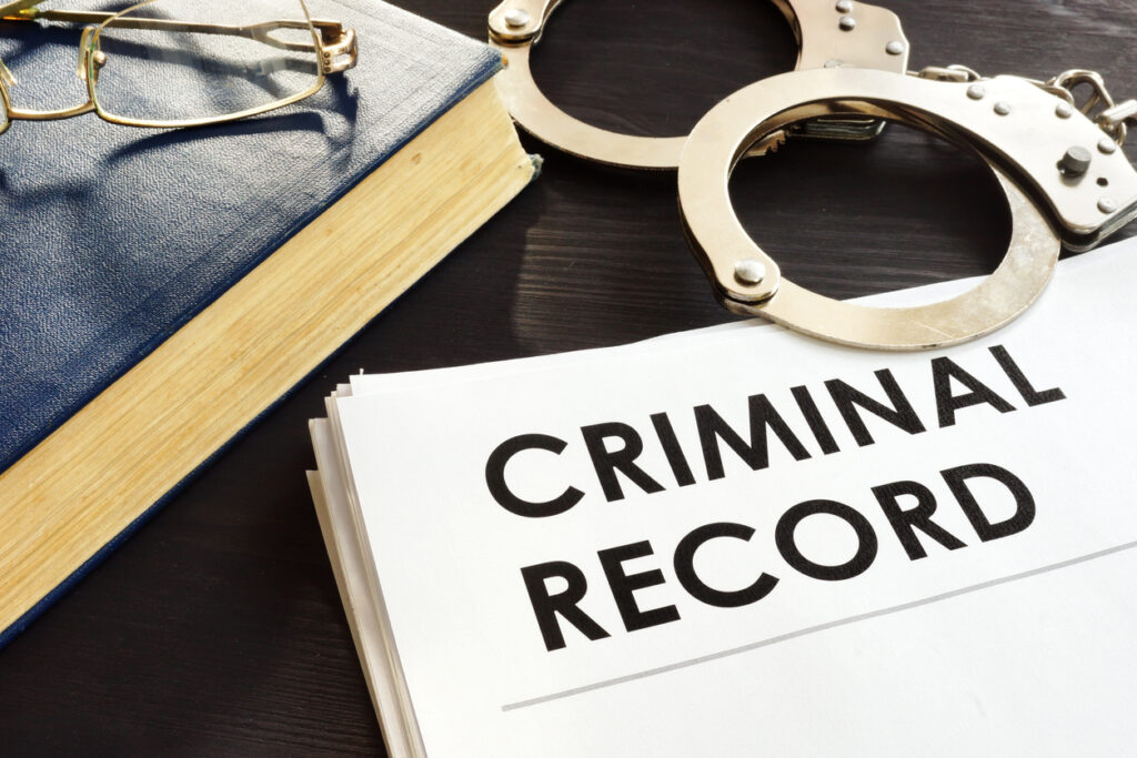 Criminal record and handcuffs on a desk