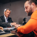 Prisoner and detectives in interrogation room