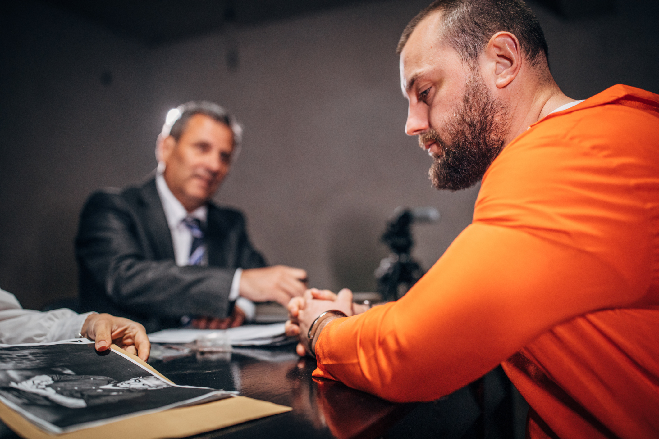 Prisoner and detectives in interrogation room